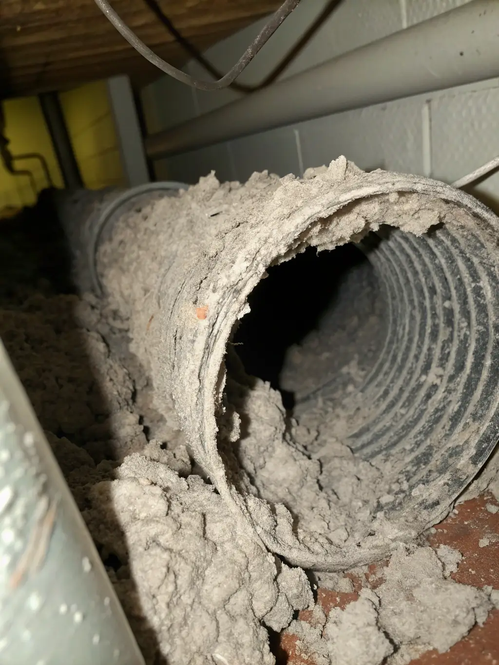 A dryer vent covered in lint, emphasizing the importance of regular cleaning to prevent fire hazards, in the context of ALO Duct Cleaning's dryer vent cleaning service.